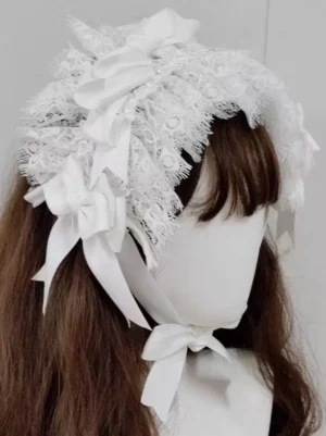 White Gothic Lolita headdress with delicate eyelash lace and satin bows, shown from rear lateral angle on mannequin with brown long wig, featuring adjustable white ribbon tie straps