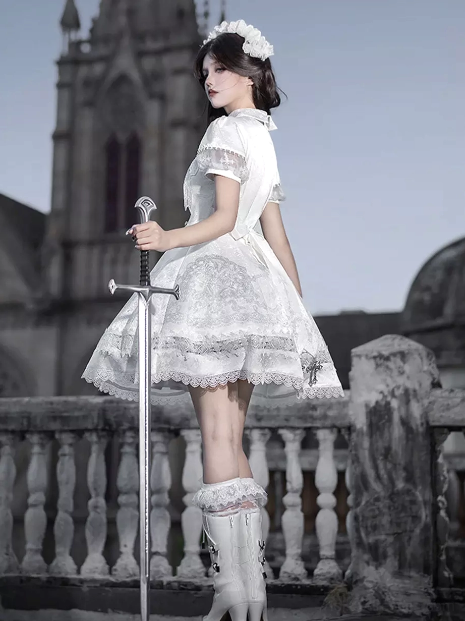 White Gothic Lolita JSK dress back three-quarter view on model wearing heeled boots and hair accessory showing short A-line skirt lace hem trim and back silhouette