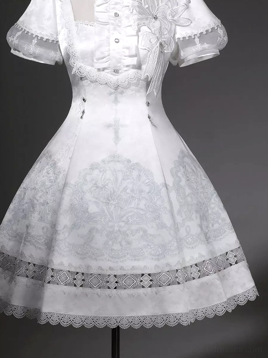 White Gothic Lolita dress flat lay showing complete dress layout with Peter Pan collar short puff sleeves A-line silhouette and all design elements visible