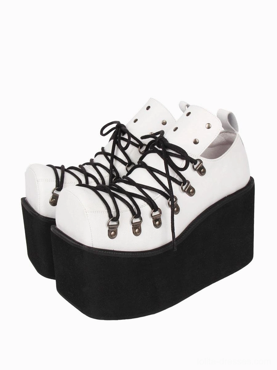 White gothic lolita platform pumps with black laces and thick wedge sole, front three-quarter paired view highlighting silver metal eyelets