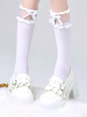 White gothic lolita sheer knee-high socks with cross bow sheer strap and white ruffled lace detailing, paired with white platform loafers, front eye-level view of lower legs