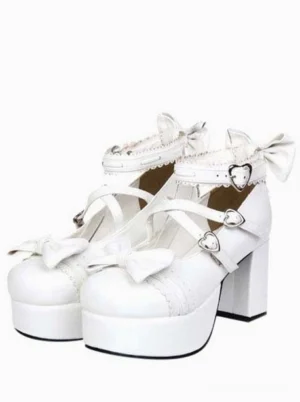 White lolita platform heels with heart-shaped buckles and cross ankle straps, front three-quarter view showing chunky block heel and decorative bow details