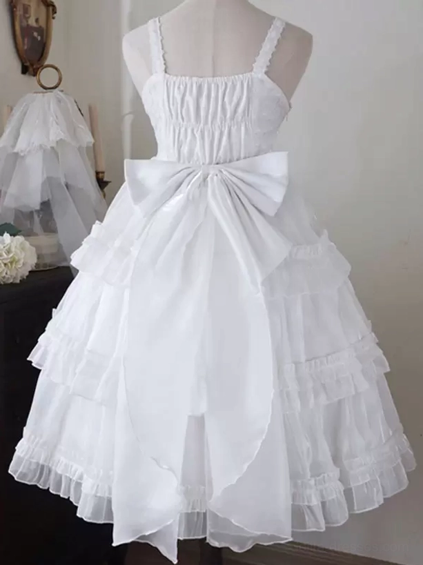 White sweet Hime Lolita dress back view displaying large structural back bow, ruched bodice detail, spaghetti strap design, and voluminous layered skirt in vintage room