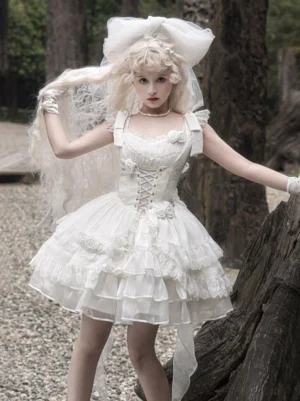 White sweet Hime Lolita JSK dress front view featuring lace-up corset bodice with 3D rose decorations and tiered ruffled tulle skirt on blonde model in outdoor woodland setting
