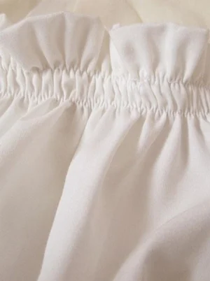 Close-up detail of elasticated shirred ruffled waistband on white lolita bloomers, showing matte cotton fabric texture and gather construction