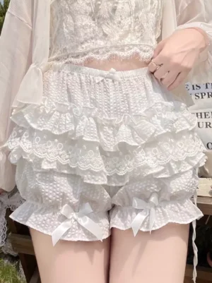 White ruffled lolita safety shorts elastic waist tiered lace trim front lower body close-up patio setting