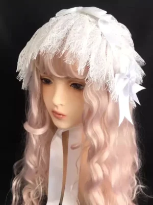 White lace Lolita headband with fringe trim and satin bows displayed frontally on mannequin with pink curly wig, long ribbon straps flowing elegantly