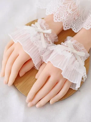 white-lace-lolita-wrist-cuffs-satin-bow-on-dummy-hands-close-up-pleated-polyester-oversleeves