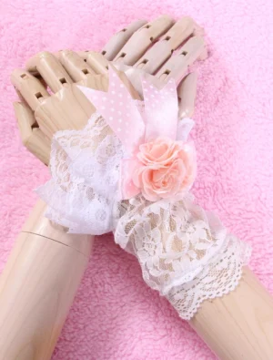 white lace lolita wrist gloves with pink roses and polka-dot bows flat lay wooden mannequin hands