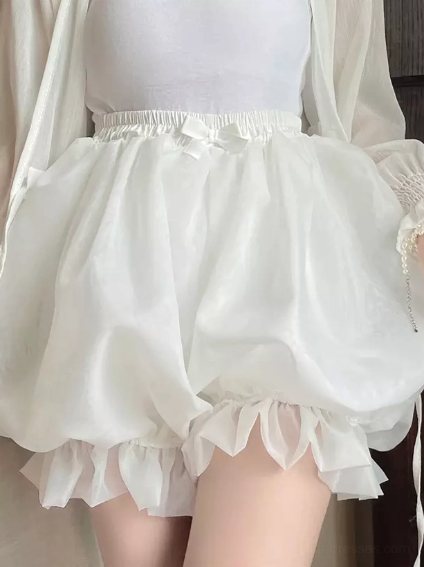 Close-up front shot white lolita bloomer shorts showcasing puffy balloon silhouette ruffled leg hem and small decorative waist bow