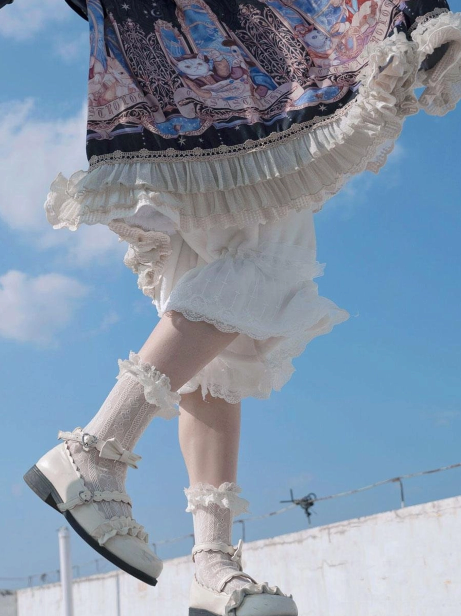 White lolita bloom shorts side view lower body outdoor blue sky lace ruffled hem with matching bow decorated flats