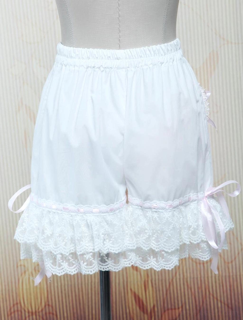 white lolita cotton bloomers right rear three-quarter view lace ruffle hems pink ribbon bows studio display