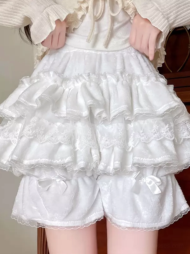 White layered lace ruffled Lolita bloomers back-focused front view with model wearing beige knit top, displaying ruffle layers and lace trim details