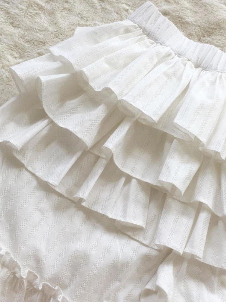 side overhead close-up view of white lolita bloomers showing multi-layer flat ruffles subtle woven jacquard fabric and elastic waistband