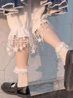 White lolita bloomers with star crochet lace hem side profile worn with black Mary Jane shoes concrete wall background