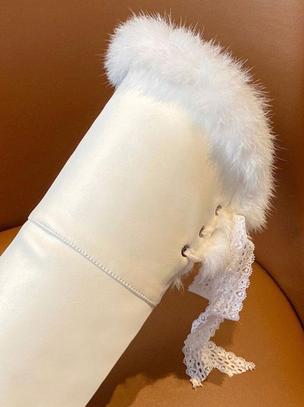 detailed close-up side view of single white lolita boot showing leather upper white fur trim and lace ribbon tie