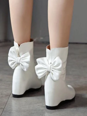 White Lolita bow ankle boots rear view with large decorative back bow and hidden wedge heel design, showcasing classic Lolita footwear aesthetic