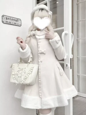 White lolita wool coat front three-quarter view worn by blonde model with ruffled handbag outdoor French doorway setting