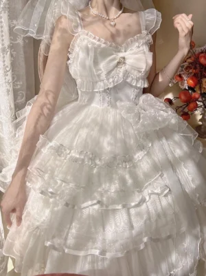 White bridal lolita jumper skirt close-up front view showcasing layered ruffles, lace trims and ornate chest bow detail
