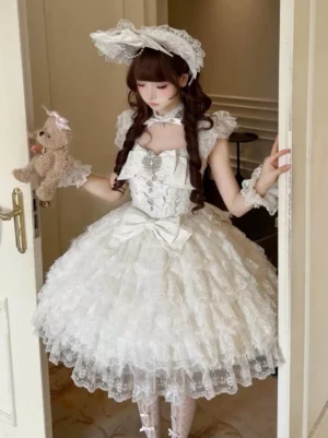 White Sweet Lolita JSK dress indoor half-body shot showing square neckline ruffled tulle skirt bow decorations lace bonnet styling