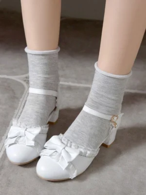 White satin bow Lolita block heel pumps with metal ankle buckle and ruffled lace trim overhead flat view with grey ankle socks