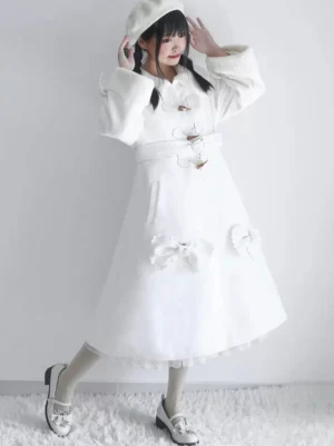 White Lolita winter coat with belted waist, ruffled hem, bow pocket embellishments, white beret, front side angle view