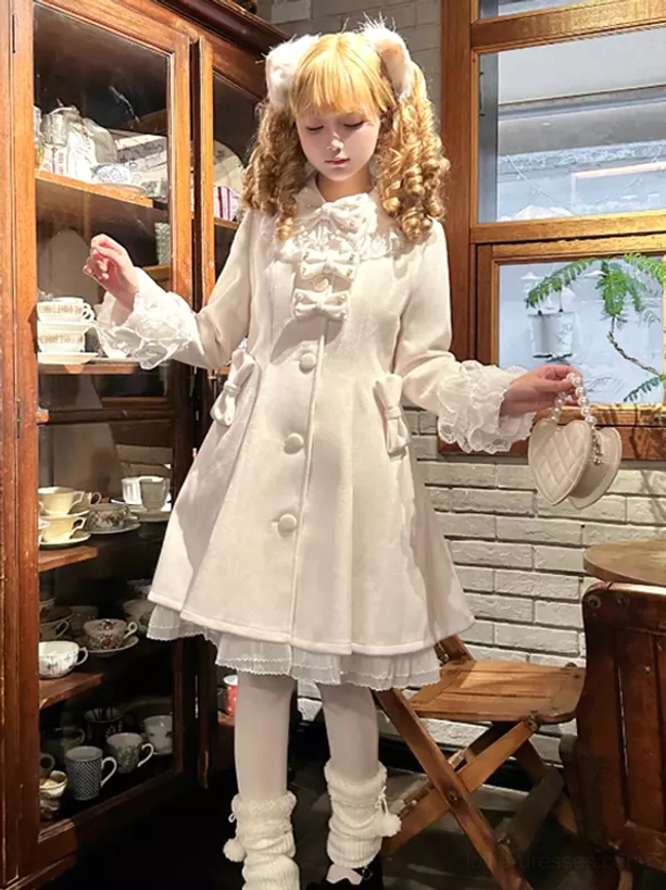 White sweet lolita overcoat side front view with side bow decor and a-line skirt hem ruffled underlayer cafe interior