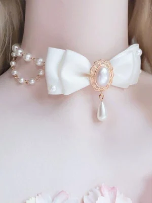Elegant white Lolita choker featuring single pearl chain and oval center pearl with satin bow detail on mannequin with floral decoration