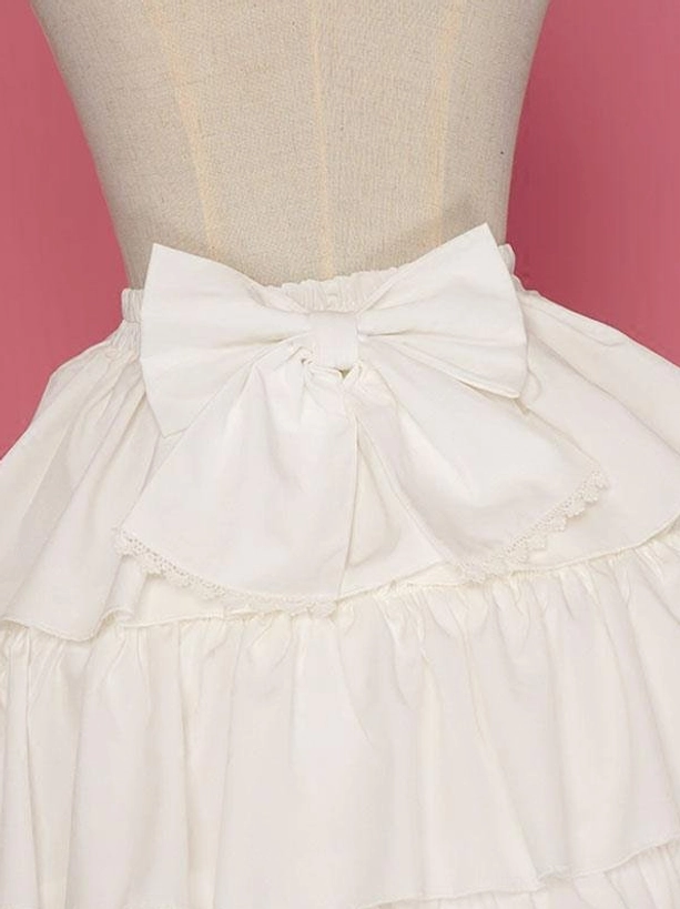 Back waist detail of white Lolita petticoat showing large decorative fabric bow and ruffled skirt layers on mannequin torso