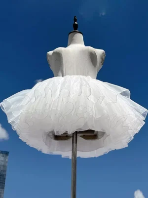 White lolita petticoat crinoline underskirt front view showing voluminous multi-layer ruffled tulle construction on mannequin with blue sky background