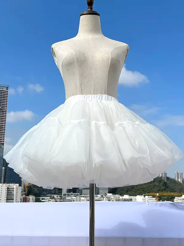 White lolita petticoat front facing view on dress form mannequin displaying tiered white tulle construction and structured puffy silhouette essential for authentic lolita coordinates on urban rooftop setting