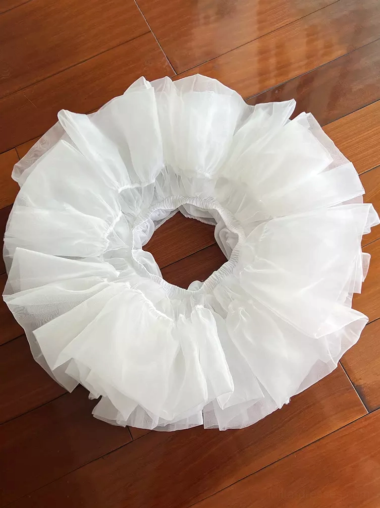 White lolita petticoat overhead flat lay view showing ruffled pure white tulle layers and circular elastic waist opening on wooden floor background for size and structure reference