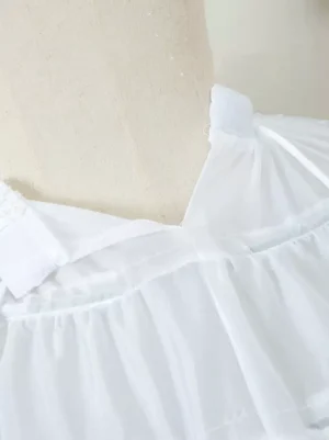 Close-up top-down view of lolita petticoat waist section showing pleated fabric adjustable strap and ruffled trim detail
