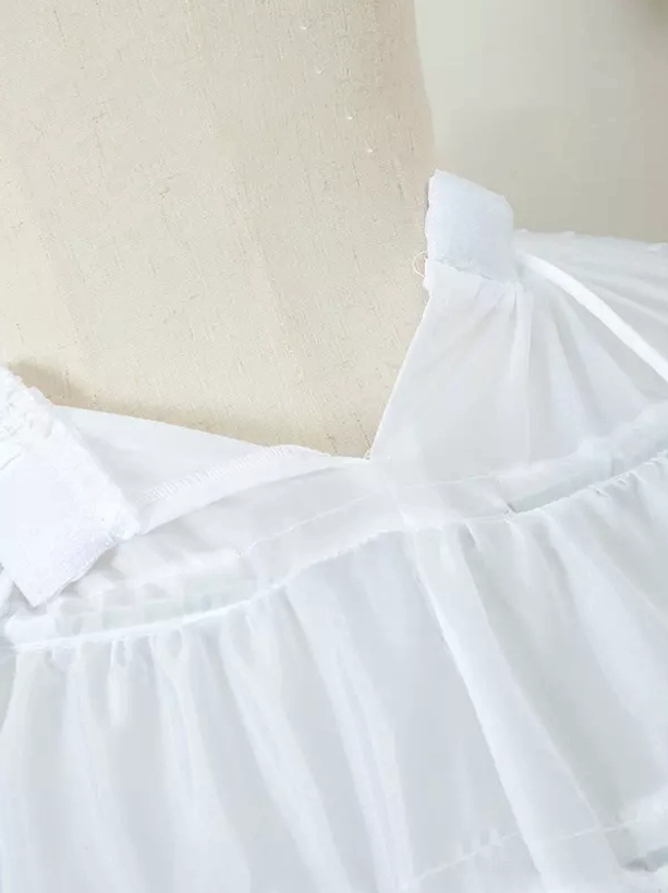 Close-up top-down view of lolita petticoat waist section showing pleated fabric adjustable strap and ruffled trim detail