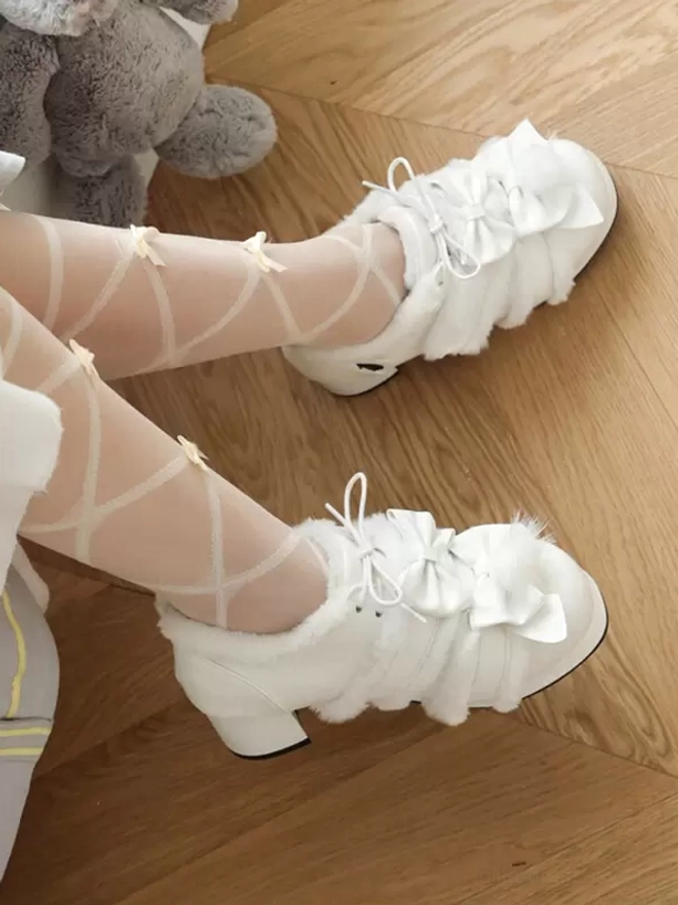 White fluffy lolita platform shoes with lace-up detail and bow accent, side front view on model wearing crisscross pattern tights