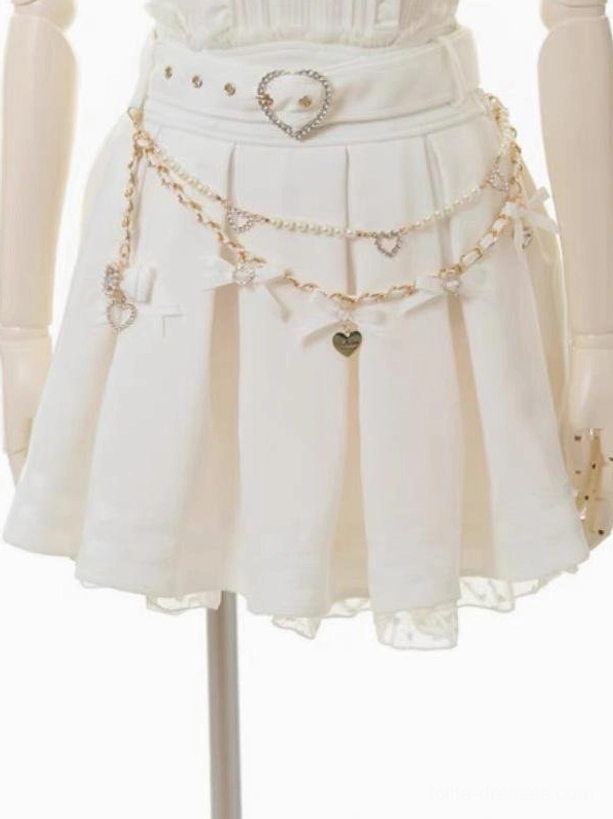 White steampunk lolita skirt front close-up showing heart belt buckle, pearl chain decorations, and sheer ruffled lace hem, mannequin display