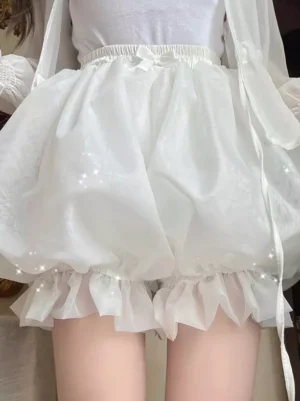 Front view of white lolita pumpkin bloomer safety shorts with delicate ruffled hem and elastic waist bow detail on indoor model
