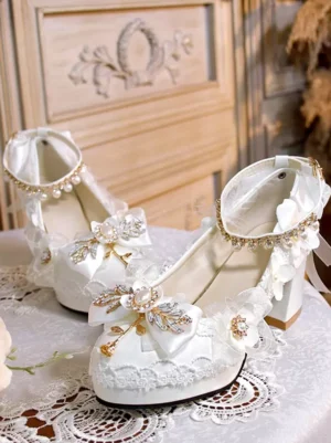 Sweet lolita pointed-toe pumps side view showing lace edge trim gem bow decoration pearl ankle bracelet detail carving wooden background