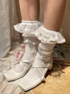 Close-up side view of white lolita ruffled stockings featuring wide ruffled lace trim and ribbed knit construction, paired with white Mary Jane shoes and elegant lace background