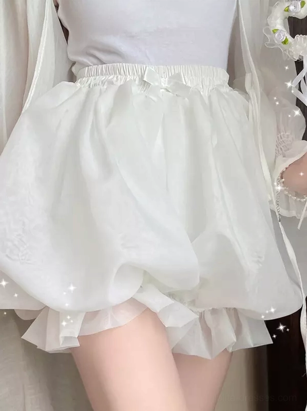 White lolita safety shorts front view with shiny polyester fabric subtle dark patterns and sparkly embellishment against floral background