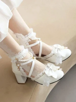 White Lolita high-heeled sandals side view showing cross ankle straps, pearl accents, decorative ruffled bow, chunky block heel worn with polka-dot lace stockings