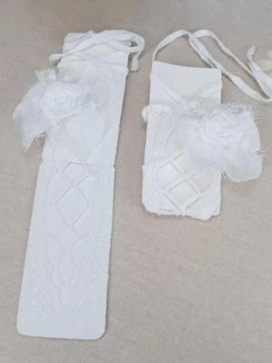 White diamond knit lolita knee socks with cream fabric roses and delicate lace-up straps, styled in flat lay arrangement showing romantic embellishments