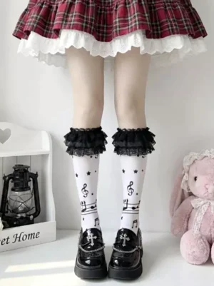 White lolita lace ruffle thigh-high socks with musical note and star prints paired with plaid ruffled skirt and platform shoes indoor home setting front view