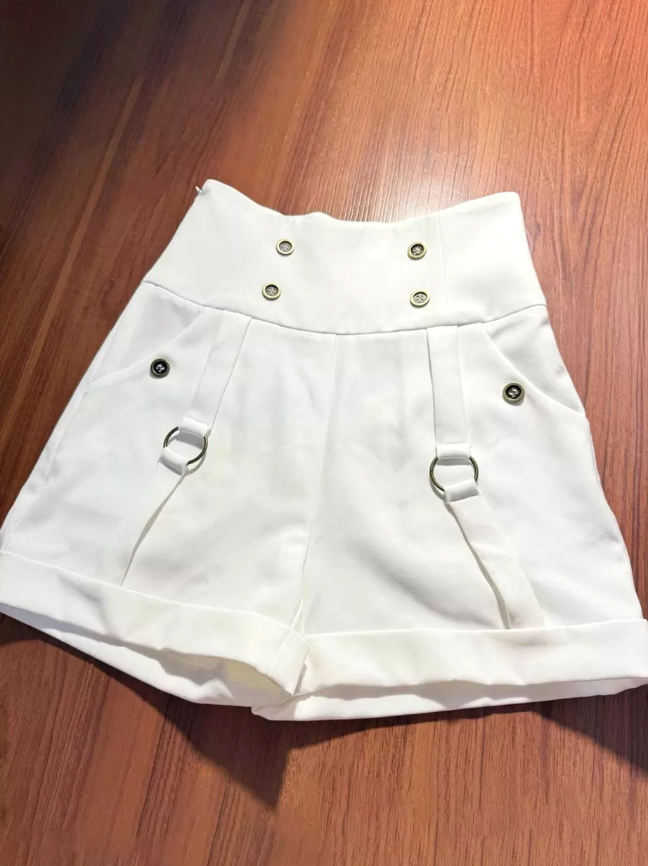 White prince ouji lolita shorts flat lay wooden background, metal fasteners high-waist silhouette multiple D-ring accents