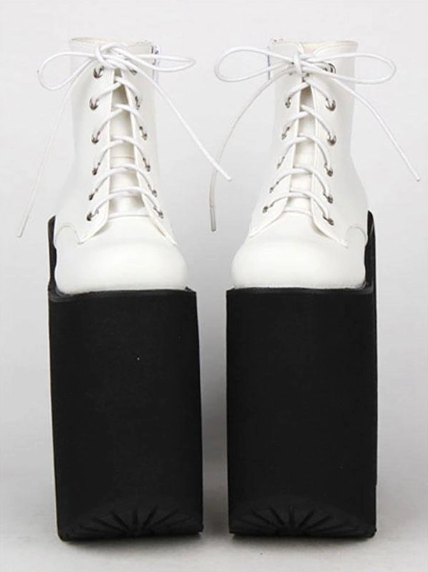 White platform ankle boots side flat lay view white laces rounded white toe cap all-black sole platform alternative fashion