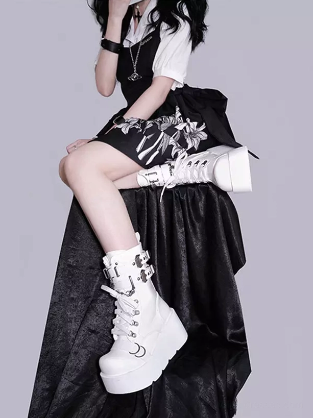 White platform combat boots low angle view worn by gothic lolita girl leaning on black fabric thick platform sole metal buckle hardware