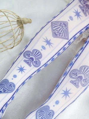 Close-up flat lay of white lolita socks featuring detailed blue poker card prints, star patterns, and striped trim on pristine background