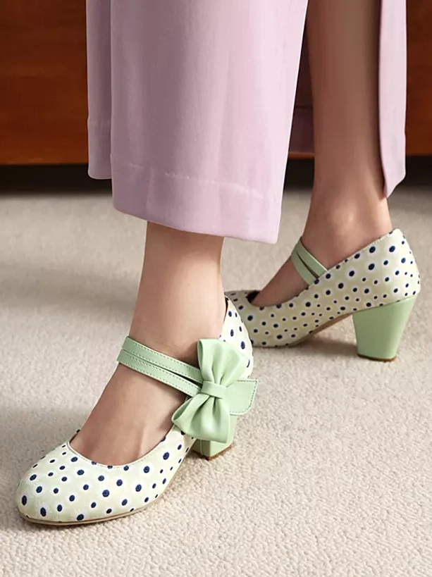 White base polka dot Mary Jane lolita shoes with dark blue dots and mint green bow on model's feet - carpeted background