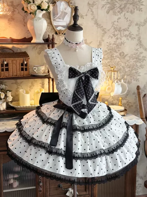 White polka dot sweet lolita JSK dress mannequin display front view with black chest bow and tiered ruffle skirt