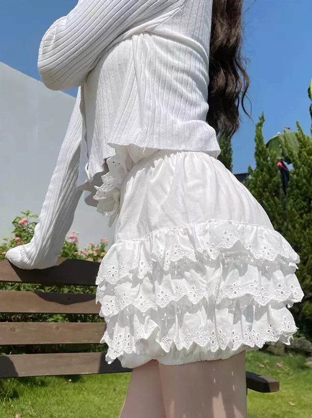 Side back view of white lolita pumpkin bloomers with smooth fabric and layered lace hem ruffles in sunny garden backdrop